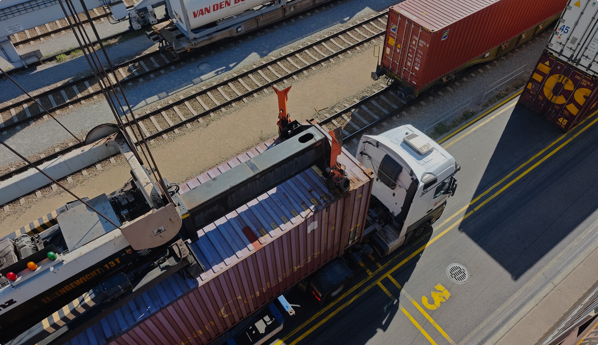 Container terminal with rail wagons and a truck seen from a crane