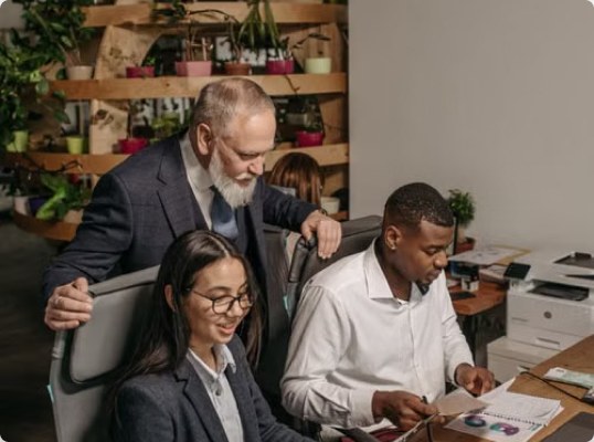 Three colleagues reviewing documents at a table